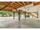 View under elevated home, showing support beams and an open area for parking with a driveway, staircase, and neighboring homes at 6001 - Mh69B South Kings Hwy., Myrtle Beach, SC 29575