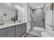 Modern bathroom with double vanity and a glass enclosed shower with gray tiling at 6013 Tramonto St., Myrtle Beach, SC 29577