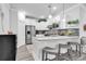 Bright kitchen with stainless appliances, white cabinets, island with seating, mosaic backsplash, and light-colored floors at 6013 Tramonto St., Myrtle Beach, SC 29577