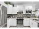 Modern kitchen featuring stainless steel appliances, white cabinets, mosaic backsplash, and quartz countertops at 6013 Tramonto St., Myrtle Beach, SC 29577