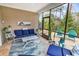 Screened patio features outdoor furniture, a blue rug and a wooded backyard view at 6013 Tramonto St., Myrtle Beach, SC 29577