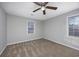 An empty bedroom with carpeted floors, neutral walls, a ceiling fan, and two windows creating a serene atmosphere at 602 Luttie Rd., Myrtle Beach, SC 29588