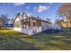 Exterior of the home with a brick sun room, screened porch, and surrounding green lawn at 602 Luttie Rd., Myrtle Beach, SC 29588