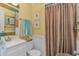 Bright bathroom with white vanity, patterned seashell shower curtain, and coastal accents at 609 Hillside Dr. S. # E-18, North Myrtle Beach, SC 29582