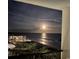 Balcony view showing a serene night scene of the moonlit ocean and the building nestled among lush vegetation at 6200 N Ocean Blvd. # 501, North Myrtle Beach, SC 29582