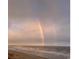 Picturesque beach view showcases a vibrant rainbow arching over the coastline and ocean, a symbol of beauty at 6200 N Ocean Blvd. # 501, North Myrtle Beach, SC 29582