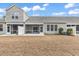 Exterior view of the home's backyard with a screened in patio and dry grass lawn at 675 Pistoia Ln. # 675, Myrtle Beach, SC 29579