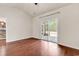 A living room featuring rich hardwood floors, neutral walls, and glass sliding doors to a screened patio at 675 Pistoia Ln. # 675, Myrtle Beach, SC 29579