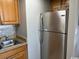 Galley kitchen featuring stainless steel refrigerator, tiled backsplash, and oak cabinets at 6804 N Ocean Blvd. # 1237, Myrtle Beach, SC 29572