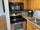 Kitchen featuring stainless steel range, black microwave, tiled backsplash, and oak cabinets at 6804 N Ocean Blvd. # 1237, Myrtle Beach, SC 29572