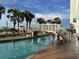 Outdoor pool area with a bridge, palm trees, and comfortable lounge chairs at 6804 N Ocean Blvd. # 1237, Myrtle Beach, SC 29572