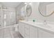 Well-lit bathroom featuring double sinks, vanity, toilet, and glass enclosed shower at 7377 Guinevere Circle, Myrtle Beach, SC 29588