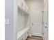 Bright mudroom with built-in bench, cubbies, coat hooks, storage cabinets, and a light gray wood-look flooring at 899 Agostino Dr., Myrtle Beach, SC 29579