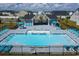 Aerial view of a sparkling community pool with lounge chairs, tables, and shaded seating areas at 899 Agostino Dr., Myrtle Beach, SC 29579