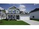 Charming two-story home with green siding, white trim, an attached two-car garage, and a well-manicured lawn at 900 Agostino Dr., Myrtle Beach, SC 29579