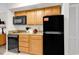 Kitchen featuring wood cabinets, granite counters, black appliances and tile floors at 9550 Shore Dr. # 1511, Myrtle Beach, SC 29572
