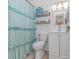 Bright bathroom with a ruffled shower curtain, white vanity, and beach-inspired decor at 1006 Charles St., North Myrtle Beach, SC 29582