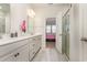 Well-lit bathroom with double sinks, a white vanity, and a glass door shower visible from doorway at 10141 Hamilton Branch Loop, Myrtle Beach, SC 29579