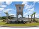 Grand community entrance with a water feature, lush landscaping, and clear blue skies at 10141 Hamilton Branch Loop, Myrtle Beach, SC 29579