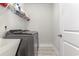 Efficient laundry room with a gray front-load washer and dryer, utility sink, and white wire shelving for organized storage at 10141 Hamilton Branch Loop, Myrtle Beach, SC 29579