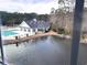 Aerial view of a community pool, clubhouse, and pond surrounded by trees at 1024 Ray Costin Way # Villa 711, Murrells Inlet, SC 29576