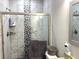 Bathroom showcasing a glass shower door, marble walls and a decorative shower tile accent at 1024 Ray Costin Way # Villa 711, Murrells Inlet, SC 29576