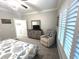 Bedroom with seahorse bedding, chair, dresser, plantation shutters and neutral decor at 1024 Ray Costin Way # Villa 711, Murrells Inlet, SC 29576