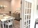 Elegant dining room with white table, gray chairs, modern chandelier, and neutral decor at 1024 Ray Costin Way # Villa 711, Murrells Inlet, SC 29576