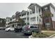 View of condo building with white balconies and brick accents, showcasing covered parking and lush landscaping at 1024 Ray Costin Way # Villa 711, Murrells Inlet, SC 29576