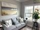 Living room featuring a comfortable grey sofa with accent pillows and a large window with a view at 1024 Ray Costin Way # Villa 711, Murrells Inlet, SC 29576