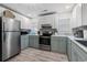Modern kitchen featuring gray backsplash, stainless appliances, and white and gray cabinets at 108 Cole Dr., Pawleys Island, SC 29585