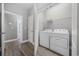 Well-organized laundry room with modern appliances, wood-style floors, and a storage shelf at 108 Silver Peak Dr., Conway, SC 29526