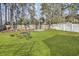 Spacious backyard with lush lawn, garden, firepit, and seating area surrounded by trees at 11 Ryan Ln., Myrtle Beach, SC 29579