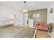 Well-lit bedroom features a bed, sofa, dresser, and decorative plants, with a modern lighting fixture at 11 Ryan Ln., Myrtle Beach, SC 29579