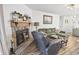 Cozy living room with brick fireplace, green sofa, and light-filled atmosphere at 11 Ryan Ln., Myrtle Beach, SC 29579