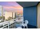 A balcony features one white chair and view of colorful sky over the building and street at 1105 S Ocean Blvd. # 446, Myrtle Beach, SC 29577