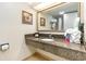 Bathroom vanity featuring granite countertop, white sink, and framed mirror with artwork, offering a luxurious touch at 1105 S Ocean Blvd. # 446, Myrtle Beach, SC 29577