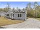 Charming gray home with a well-kept lawn, featuring a curved driveway and a welcoming entrance at 1110 N Middleton Dr. Nw, Calabash, NC 28467
