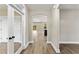 Bright hallway featuring wood-look flooring, white trim, and a glimpse into the open-concept living area at 1110 N Middleton Dr. Nw, Calabash, NC 28467