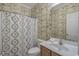 Inviting bathroom with unique wallpaper, vanity with sink, and shower-tub combination at 113B 13Th Ave. N, Surfside Beach, SC 29575