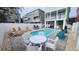 Inviting pool area with white fence, outdoor seating, lounge chairs, and beautiful landscaping at 113B 13Th Ave. N, Surfside Beach, SC 29575