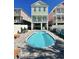 Charming home with a private kidney-shaped pool, surrounded by a paved patio and comfortable seating areas at 113B 13Th Ave. N, Surfside Beach, SC 29575