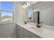 Ensuite bathroom with double sink vanity, dark faucet fixtures, and bright natural light at 115 S Middleton Dr. Nw, Calabash, NC 28467