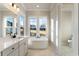 Bathroom with a freestanding tub, marble floors, double windows, and modern fixtures at 115 S Middleton Dr. Nw, Calabash, NC 28467