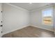 Well-lit bedroom with wood flooring and a large bright window at 115 S Middleton Dr. Nw, Calabash, NC 28467