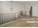 Hallway with hardwood floors, wrought iron railings, and a modern lighting fixture at 115 S Middleton Dr. Nw, Calabash, NC 28467