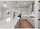 Bright kitchen featuring white cabinets, a large island, pendant lights, and stainless steel appliances at 115 S Middleton Dr. Nw, Calabash, NC 28467