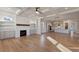 Spacious living room seamlessly connecting to a modern kitchen with a fireplace and hardwood flooring at 115 S Middleton Dr. Nw, Calabash, NC 28467