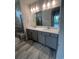 Modern bathroom features dual sinks, stone countertops, and a tiled shower with a glass door at 1241 Lady Bird Way, North Myrtle Beach, SC 29582