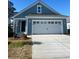 Charming blue single-story home with a two-car white garage and a well-maintained lawn at 1241 Lady Bird Way, North Myrtle Beach, SC 29582